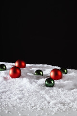 Christmas, New Year banner, snowy decoration, red and green Christmas tree balls lying in the snow.