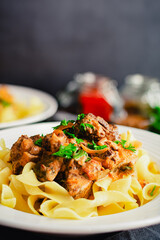 German Goulash Served Over Egg Noodles in a Shallow Bowl: Simmered chunks of beef seasoned with...