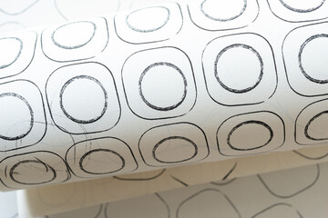 close-up of rolled paper with abstract sketchbook paper featuring black ink circles in rounded corner squares