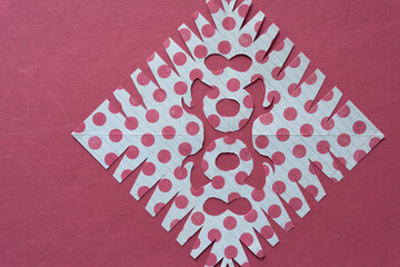 polka dot decorative paper design mimicking the delicate pattern of snowflakes on rough red paper