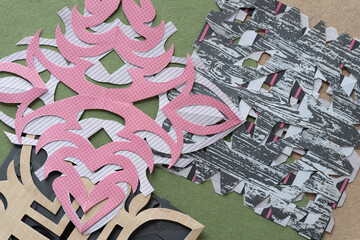 layered decorative paper designs mimicking the delicate patterns of snowflakes on rough green paper