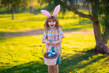 Bunny child. Child boy hunting easter eggs. Cute kid in rabbit costume with bunny ears having...