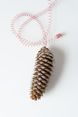 diy holiday craft pine cone with painted bracts and a coiled metal wire 