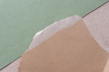 paper texture background consisting of rough green paper arranged diagonally and torn plain brown...