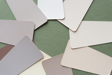 analogous paint-chip sample cards with rounded corners arranged in a radial pattern on rough green...