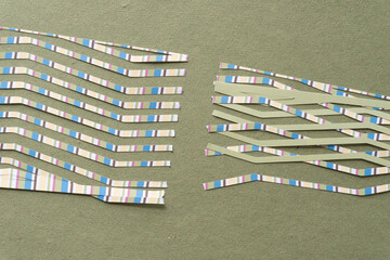 scrapbook with stripes machine-cut into narrow strips of paper and arranged on rough green paper