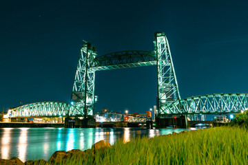 A captivating long exposure night photograph of the Koninginnebrug bridge in Rotterdam, showcasing...