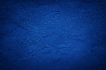 Black dark blue painted concrete wall. Toned grunge background. Rough grainy plaster texture surface. Bright deep color. Cobalt shade. Exterior. Close-up. Design. Empty space. - obrazy, fototapety, plakaty