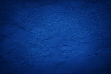 Deurstickers Black dark blue painted concrete wall. Toned grunge background. Rough grainy plaster texture surface. Bright deep color. Cobalt shade. Exterior. Close-up. Design. Empty space. © Наталья Босяк