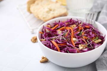 Tasty salad with red cabbage and walnuts on white table, closeup. Space for text