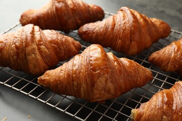 Delicious fresh croissants on grey table, closeup
