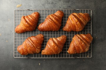 Delicious fresh croissants on grey table, top view