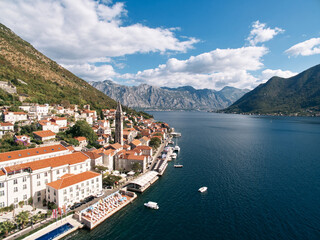 Fototapeta na wymiar Swimming pool and private beach on the shore of the Bay of Kotor overlooking ancient houses. Perast, Montenegro. Drone