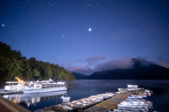 北海道　夜の然別湖に浮かぶ船と輝く星空