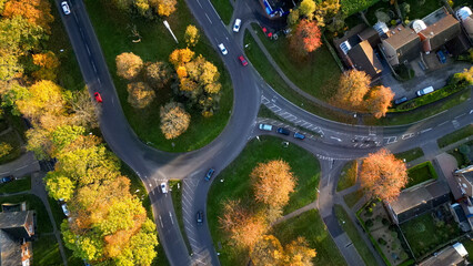 Aerial View of a Winding Road Through Autumn Trees with Cars