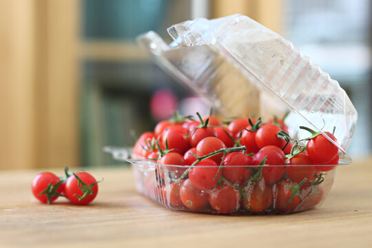 tomates cereja maduros e frescos sobre a mesa de madeira da cozinha em foco seletivo e luz natural