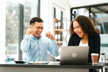 Asian business man and African American woman engaging in business discussion, possibly about merger or joint venture. two companies become one, one of companies often survives while other disappears