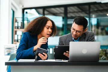 Asian business man and African American woman engaging in business discussion, possibly about merger or joint venture. two companies become one, one of companies often survives while other disappears