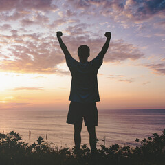 Man raising fists up the sunset sky