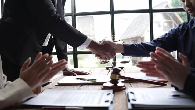 Lawyer shakes hands with businessman to close deal with partner lawyer Or a lawyer is discussing an employment contract agreement.