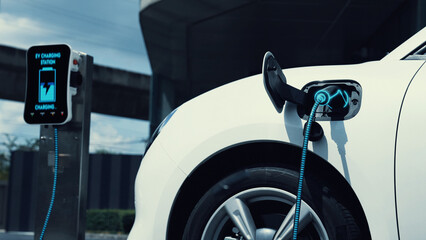 Electric car recharging with EV charger from charging station at public car park. Future innovative...