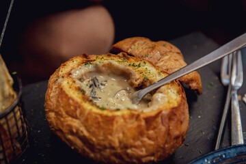 Gourmet Creamy Mushroom Soup in Artisan Bread Bowl on Dark Slate Table