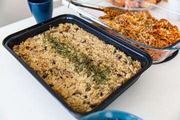 Homemade Creamy Chicken and Mushroom Risotto Garnished with Herbs in a Baking Dish