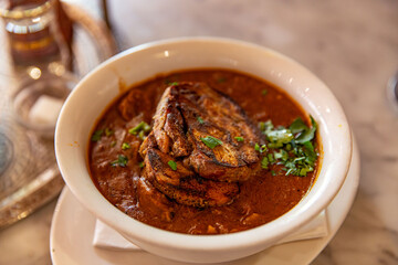 Hearty Bread Stew Soup in a White Bowl, Topped with Fresh Herbs, Perfect Comfort Food