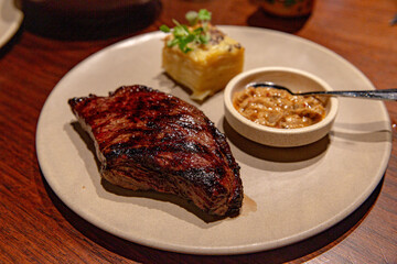 Perfectly Grilled Steak Paired with a Creamy Potato Mash, Presented on Earthy Stoneware