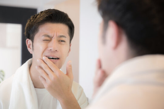 歯が痛い男性　ちょっと痛いししみるかも～知覚過敏や虫歯のイメージ