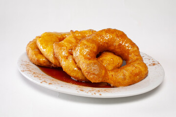 A dish of a sweet potato dessert of peruvian food, called "picarones" like a peruvian donuts