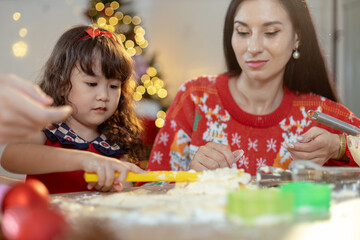 Little girl enjoying make cooking bakery desserts on food table holiday merry festive activities. Happy family christmas day. Parents and daughter celebrate Christmas happily in their own home.