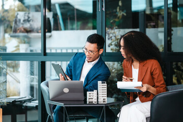 Attractive Asian businessman and African American female real estate and land investor talk...