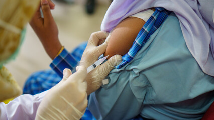 photo of a doctor holding a patient and injecting the patient with the tetanus vaccine