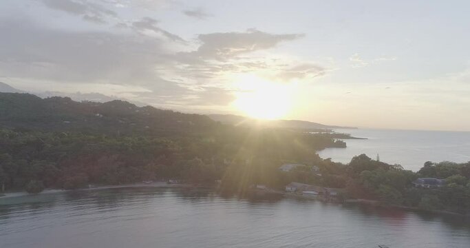 Drone footage of the sun setting over the Drapers Beach on the Caribbean Sea on Drapers, Jamaica