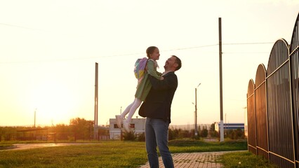 child runs into arms happy father. happy schoolboy spins his father arms. dream flying. girl runs...