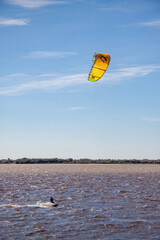 Kitesurfer rolls and maneuvers through the waves on the river