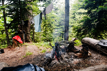 camp, tourists dry clothes and shoes by the campfire