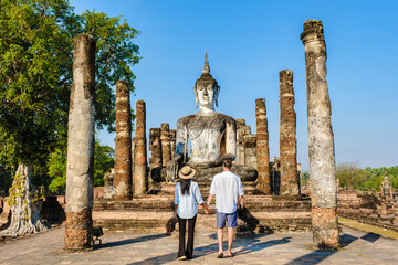 A Couple of men and women visit Wat Mahathat Sukhothai, an old city in Thailand. Ancient city and...