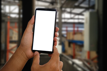 Engineer hand held black phone with a blank white screen in the office in the morning light.