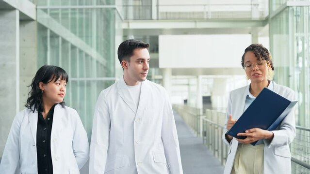 A multinational group having a conversation in the lobby.
People in white coats and sales staff. High angle view.