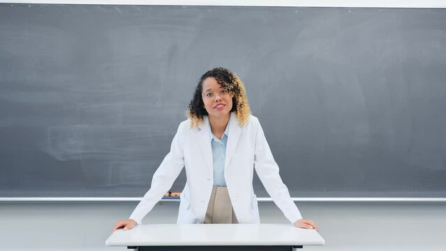 Female teacher teaching in front of the blackboard in the classroom.
