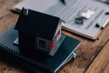 Real estate broker agent presenting and consult to customer to decision making sign insurance form agreement, buy and sell home model, concerning mortgage loan offer for and house insurance