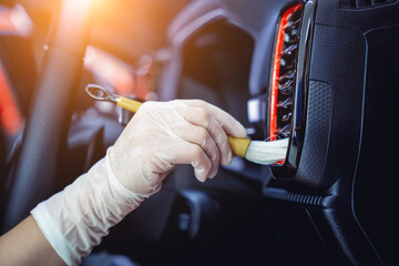 Young woman cleaning the car interior using a special brush with foam