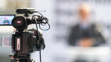 TV camera records a speaker on stage, delivering impactful insights and engaging the audience, on...