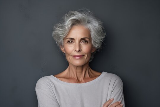 Closeup Portrait Of Beautiful Older Woman Next To Grey Wall