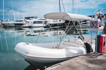 Many white modern yachts moored at the pier of marina.