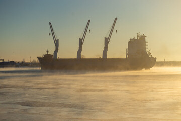  Cargo ship, ice classed bulk carrier in the ice and fog of a freezing river. High quality photo