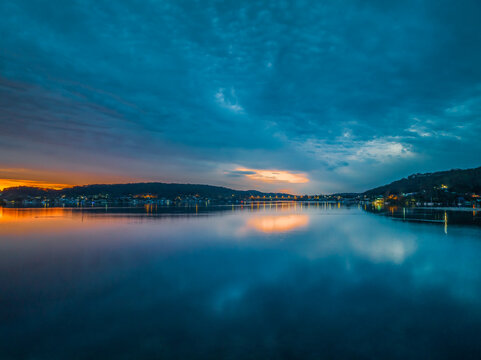 Heavy cloud covered sunrise over the bay with colour and reflections