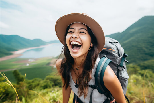Happy, cheerful Asian girl tourist against the backdrop of mountains and sea in summer